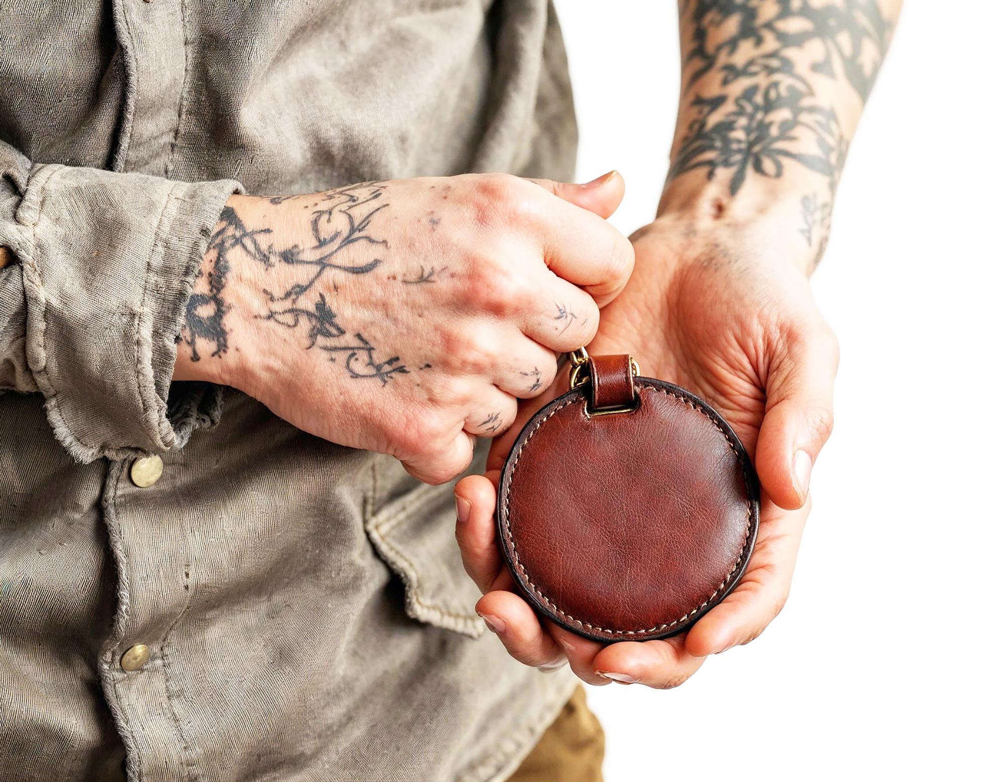Artist showing embroidered badge in studio